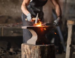 Un forgeron travaille le métal avec précision pour créer des structures solides. Ensuite, il maîtrise les techniques de forge
